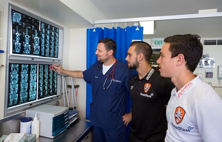 St Andrew's emergency doctor Peter Forgiarini with Roar players Jack Hingert (in black) and Devante Clut (in white).