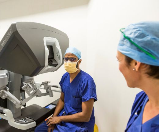 A doctor sitting at a Da Vinci machine.