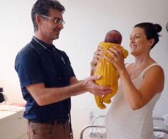 A doctor and a mum lift her baby